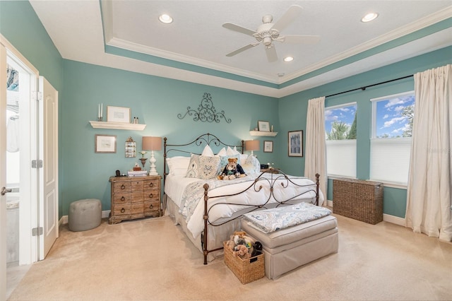 carpeted bedroom with ornamental molding, ceiling fan, and a tray ceiling