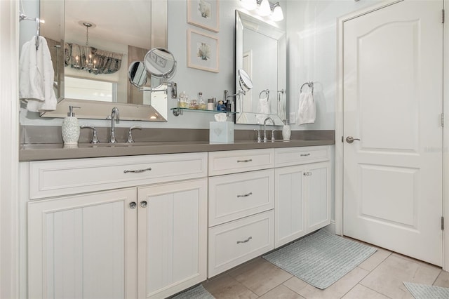 bathroom with vanity, an inviting chandelier, and tile patterned flooring