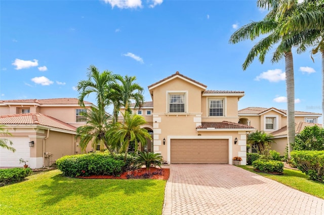 mediterranean / spanish-style home featuring a front yard and a garage