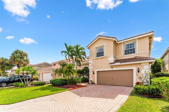 mediterranean / spanish-style home featuring a front yard and a garage