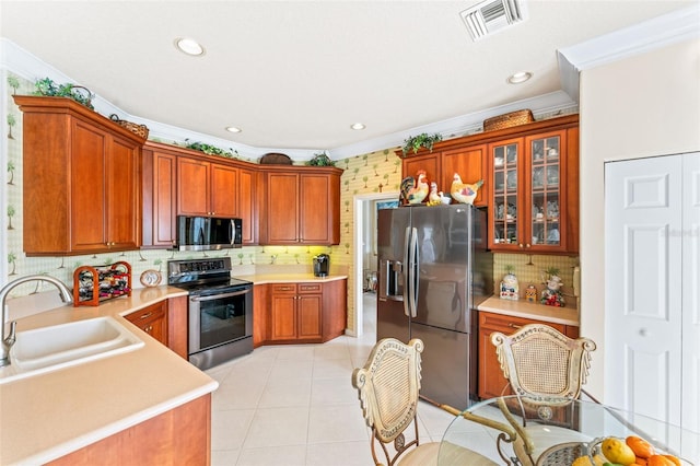 kitchen featuring sink, tasteful backsplash, light tile patterned floors, ornamental molding, and appliances with stainless steel finishes