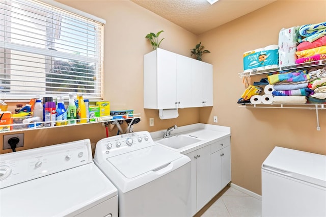 washroom featuring sink, cabinets, separate washer and dryer, a textured ceiling, and light tile patterned floors