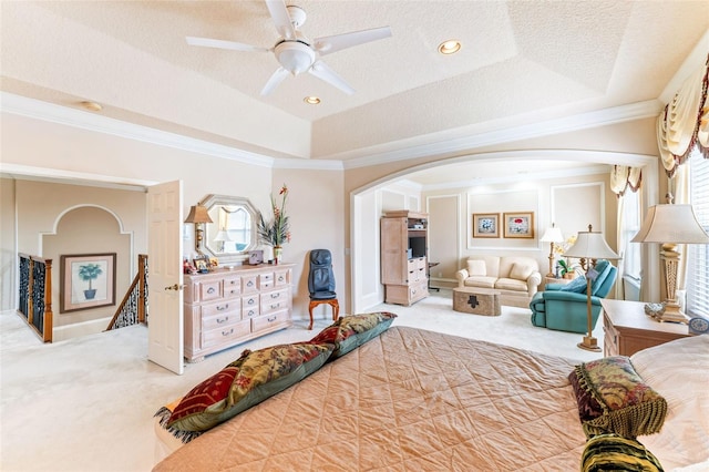 bedroom featuring a raised ceiling, ornamental molding, carpet flooring, and a textured ceiling