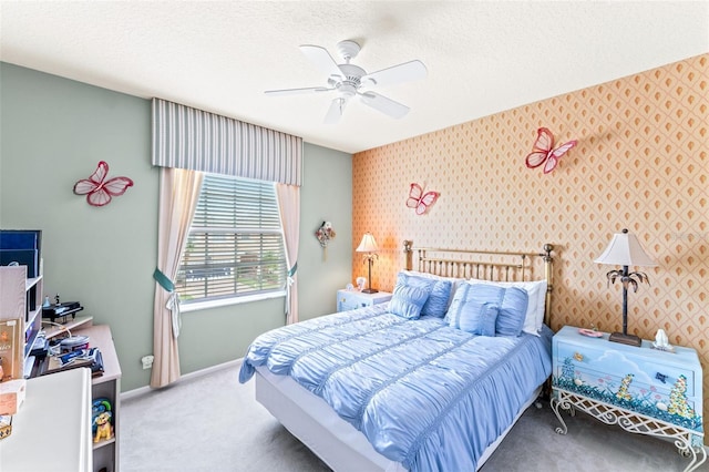 carpeted bedroom featuring ceiling fan and a textured ceiling