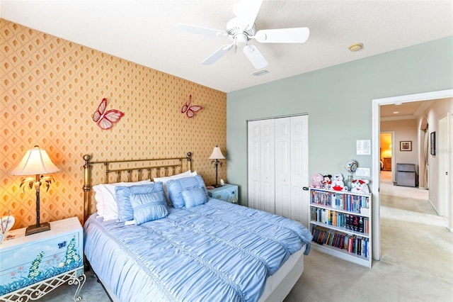 carpeted bedroom with ornamental molding, a closet, and ceiling fan