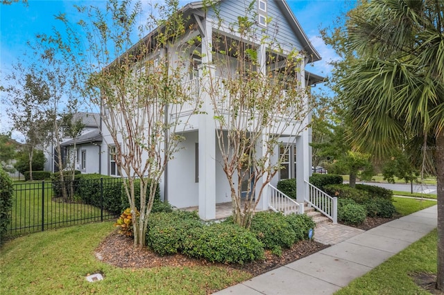 view of side of property featuring a porch and a lawn