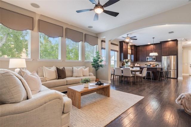 living room with dark hardwood / wood-style flooring and ceiling fan