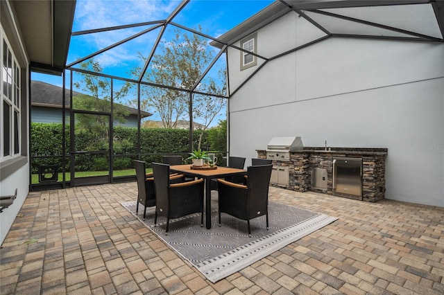 view of patio / terrace featuring a lanai, area for grilling, and exterior kitchen