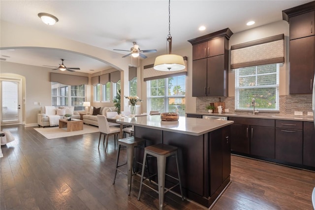 kitchen with dark hardwood / wood-style flooring, sink, decorative backsplash, and a center island