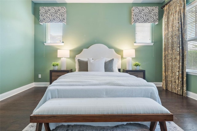 bedroom with dark hardwood / wood-style flooring and multiple windows