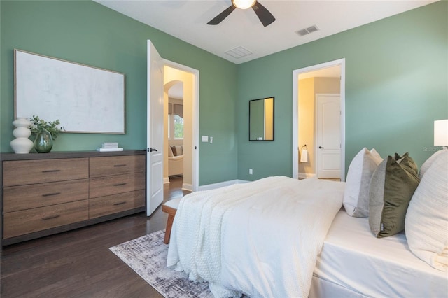 bedroom featuring ceiling fan, dark hardwood / wood-style floors, and connected bathroom