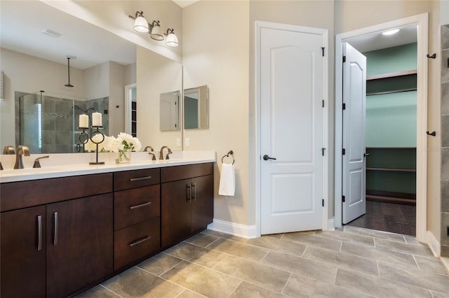 bathroom with tile patterned flooring, tiled shower, and vanity