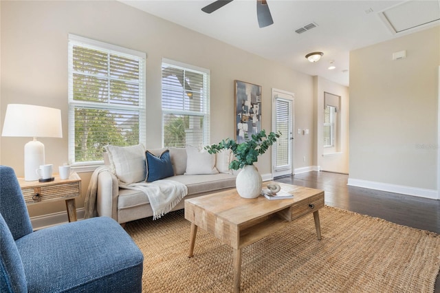 living room featuring dark wood-type flooring and ceiling fan