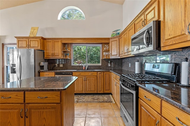 kitchen with stainless steel appliances, plenty of natural light, sink, and a center island