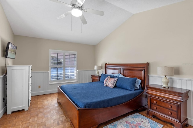 bedroom with ceiling fan, light parquet floors, and vaulted ceiling