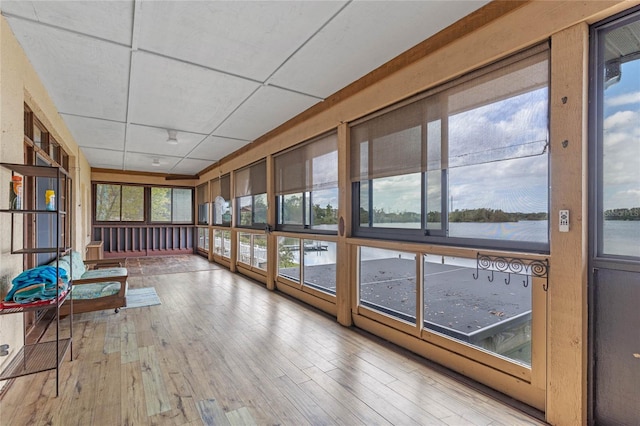 unfurnished sunroom with a water view and a drop ceiling