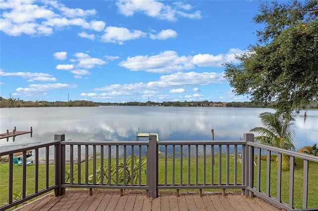 wooden terrace with a water view, a yard, and a boat dock