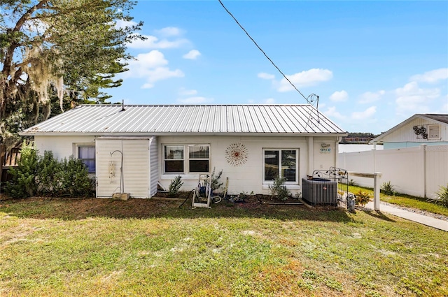 back of property featuring a lawn and cooling unit