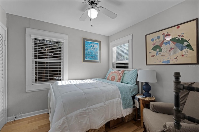 bedroom with light hardwood / wood-style flooring, ceiling fan, and a closet