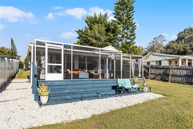 rear view of house with a sunroom and a yard