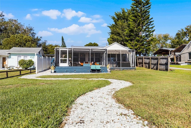 back of property featuring a lawn and a sunroom