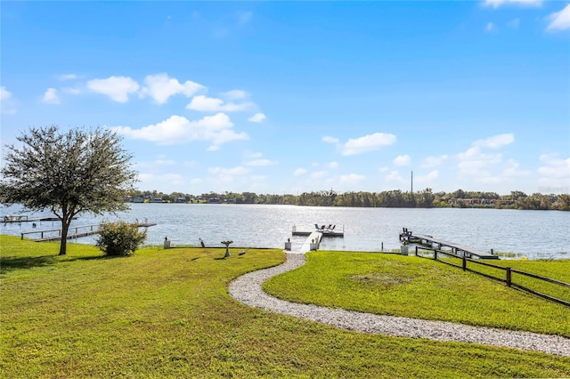 view of dock with a yard and a water view