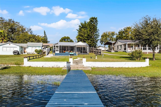 view of dock with a water view and a yard