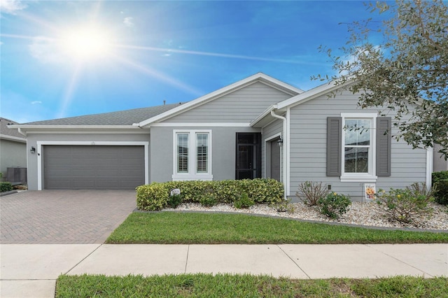 single story home featuring a garage and cooling unit