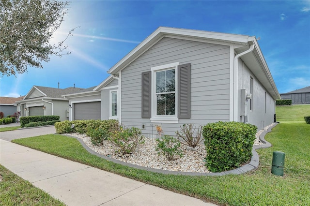 view of property exterior with a garage and a lawn