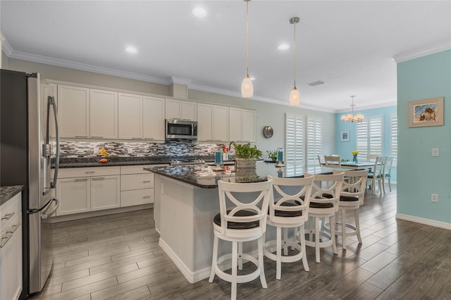 kitchen featuring stainless steel appliances, white cabinets, and a kitchen island with sink