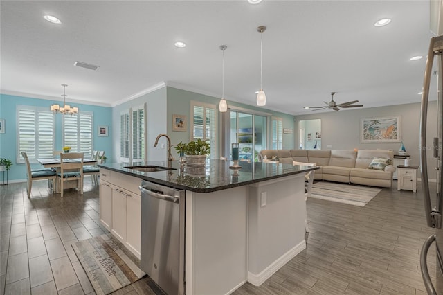 kitchen with a center island with sink, dishwasher, white cabinets, sink, and decorative light fixtures