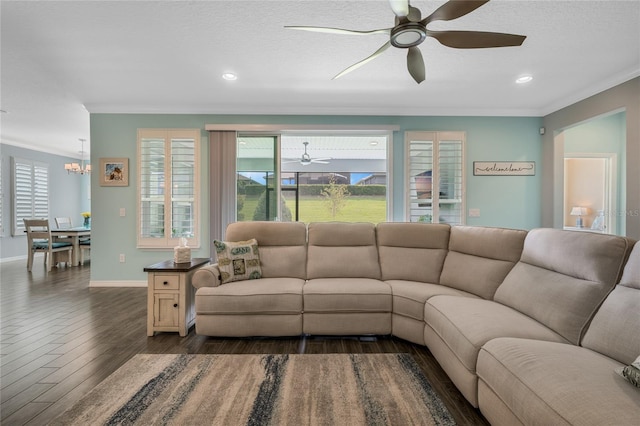 living room with ornamental molding, ceiling fan with notable chandelier, dark hardwood / wood-style flooring, and a textured ceiling