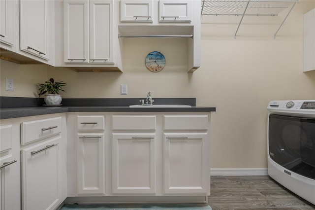 laundry room with dark hardwood / wood-style flooring, cabinets, sink, and washer / dryer