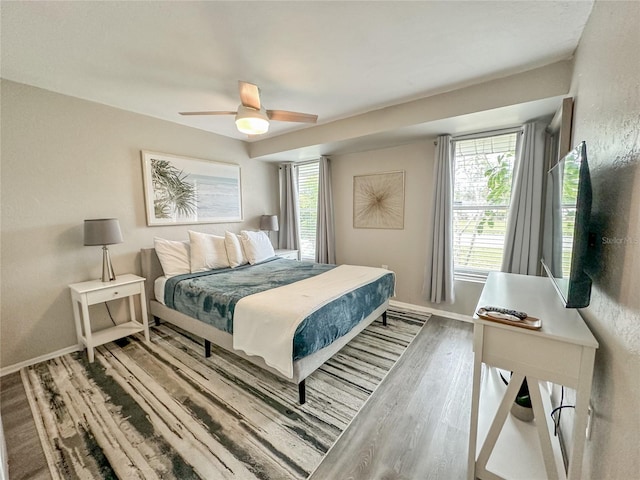 bedroom with hardwood / wood-style floors, multiple windows, and ceiling fan