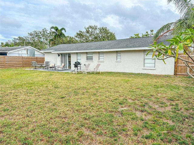 rear view of property featuring a yard and a patio