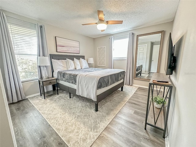 bedroom featuring a textured ceiling, light hardwood / wood-style flooring, and ceiling fan