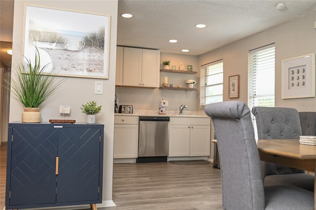 kitchen featuring dishwasher, white cabinets, a textured ceiling, and light hardwood / wood-style flooring