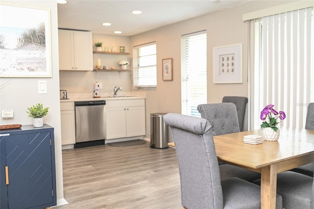 interior space with sink, dishwasher, white cabinets, and light wood-type flooring