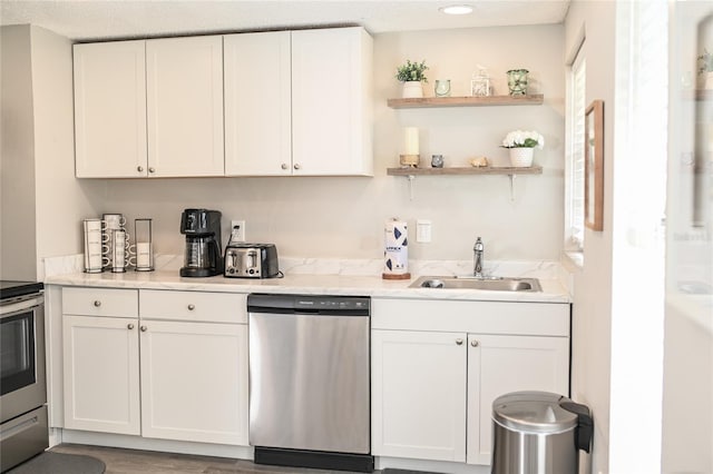 kitchen featuring wood-type flooring, white cabinetry, sink, and appliances with stainless steel finishes