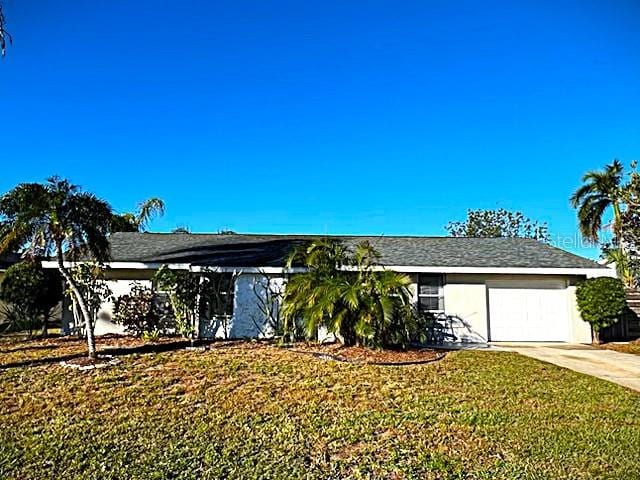 ranch-style house featuring a garage and a front lawn