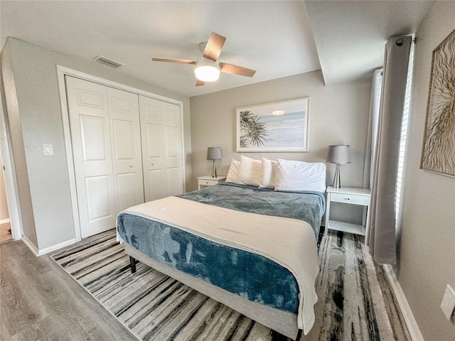 bedroom featuring ceiling fan, wood-type flooring, and a closet