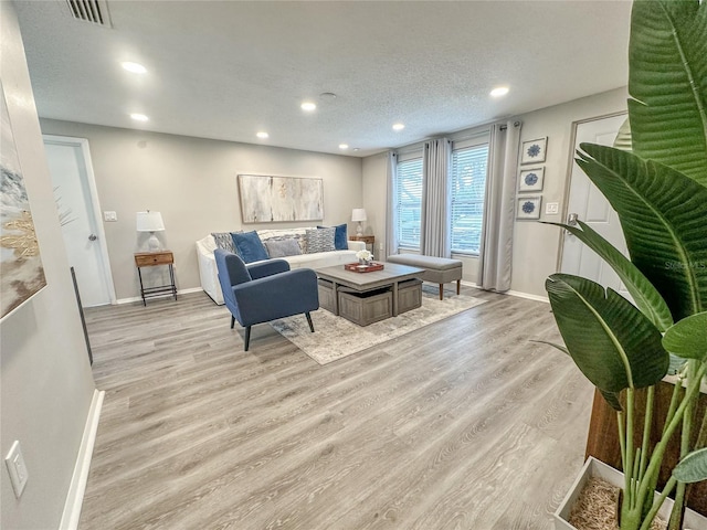 living room with light hardwood / wood-style floors and a textured ceiling