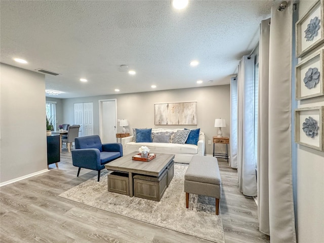 living room featuring a textured ceiling and light hardwood / wood-style flooring