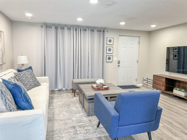 living room with a textured ceiling and light hardwood / wood-style floors