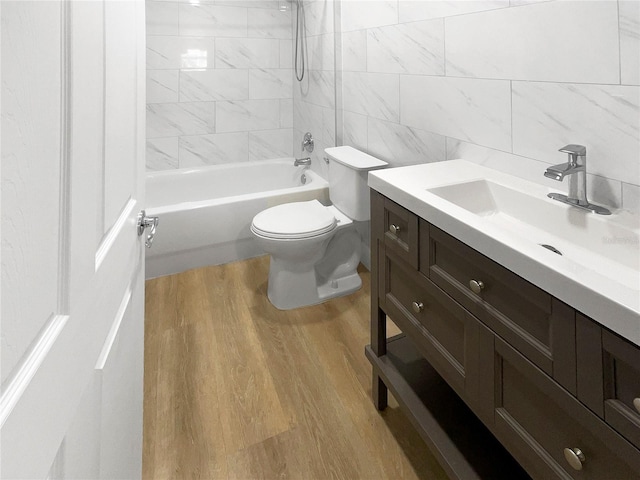 736 Mac Crillus Rd, Largo, FL 33770 - full bathroom with wood finished floors, toilet, vanity, tile walls, and shower / bathtub combination