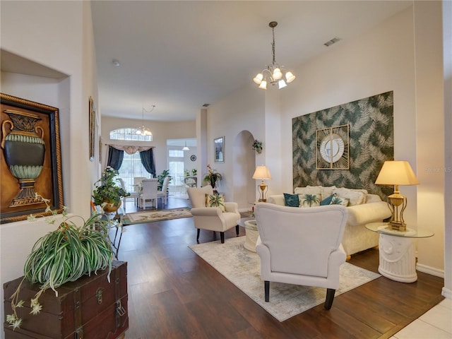 living room featuring dark wood-type flooring and an inviting chandelier