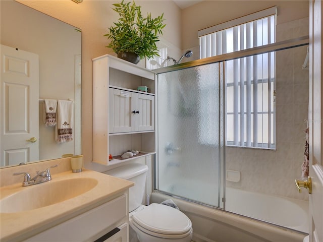 full bathroom with toilet, vanity, and shower / bath combination with glass door