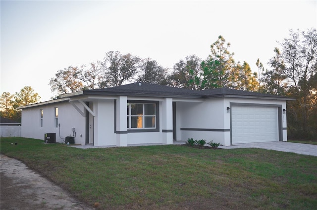 single story home with central AC, a garage, and a front lawn