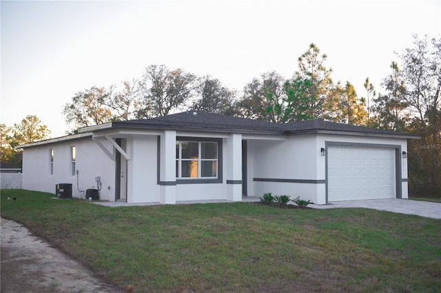 ranch-style home featuring central AC, a garage, and a front lawn