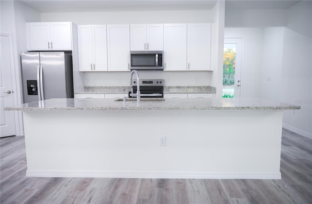 kitchen featuring a center island with sink, sink, white cabinetry, and stainless steel appliances